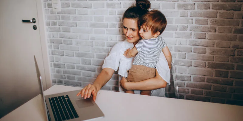 mujer trabajando con niño en brazos