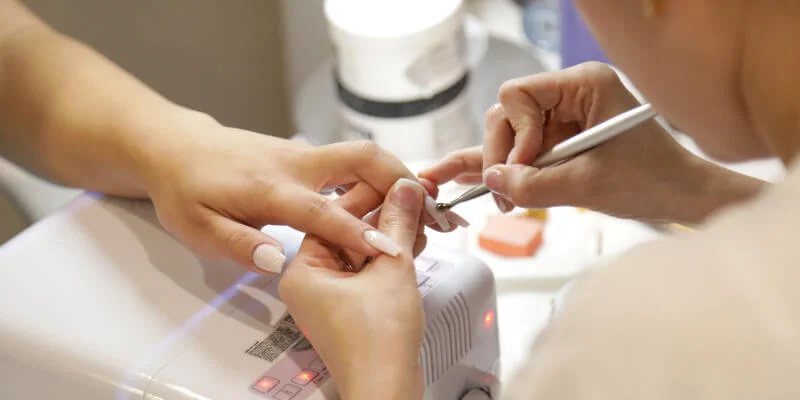 Mujer haciendo manicura a otra