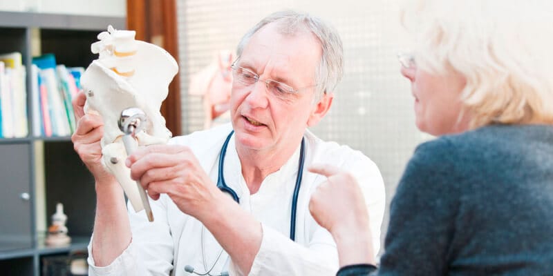 médico explicando a paciente prótesis de cadera