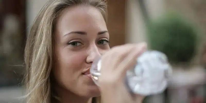 mujer bebiendo agua para el hígado