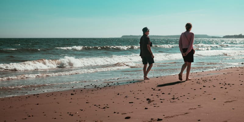 personas caminando por la playa